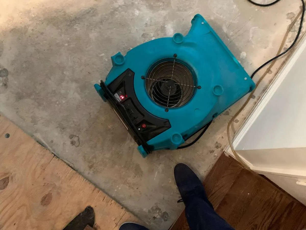 Air mover drying subfloor during Commercial Water Damage Restoration in Candler-McAfee